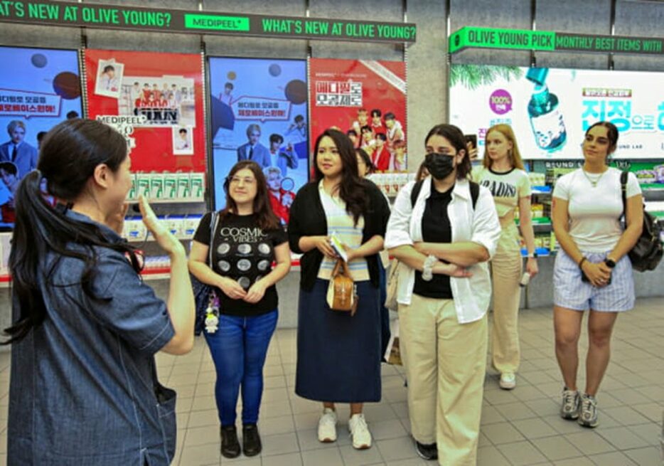 オリーブヤングの店員の説明を聞く、K－ビューティードーセントプログラムに参加した外国人観光客(c)KOREA WAVE