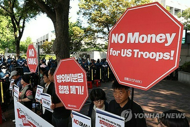 会合が行われる韓国国防研究院の前では、SMAの締結に反対する市民団体が交渉の中止を求めて記者会見を行った＝25日、ソウル（聯合ニュース）