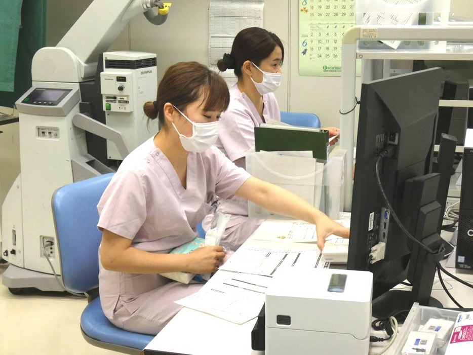 患者の情報を確認する応援チームの看護師。一般病棟の看護業務を分担して支援する＝20日、静岡市葵区の市立静岡病院