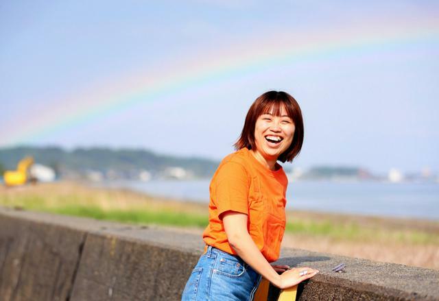 「地震日記」をZINEにした鹿野桃香さん。取材中、海に大きな虹がかかり、笑顔を見せた=2024年6月2日、石川県珠洲市、林敏行撮影