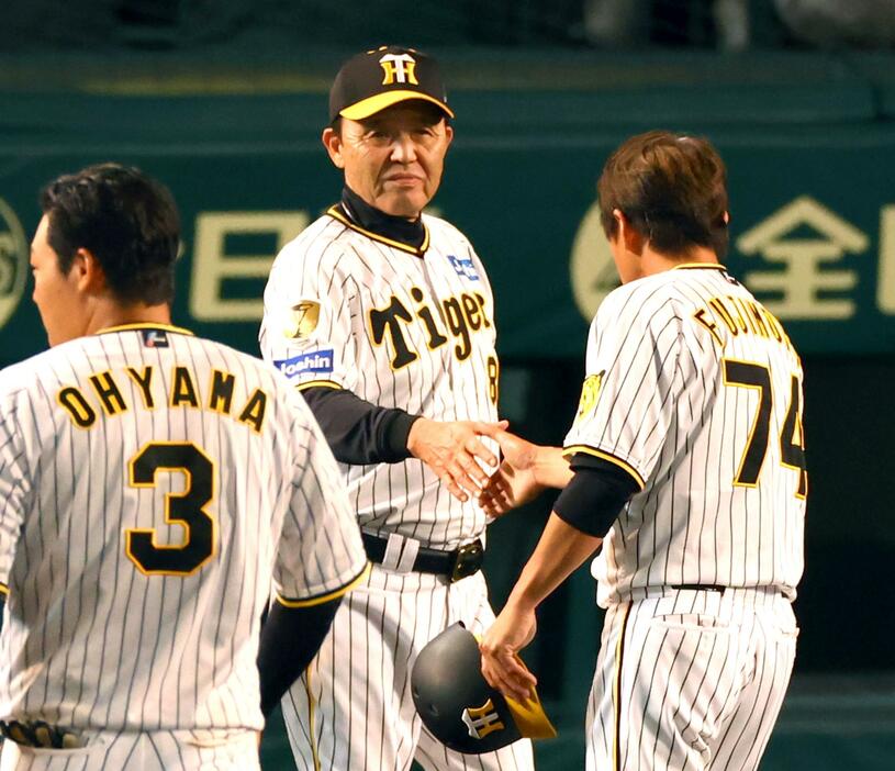 　サヨナラ勝ちし、岡田監督（中央）は藤本コーチと握手する（撮影・山口登）
