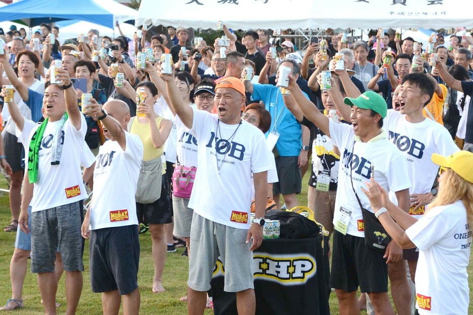 レース完走へ向けて乾杯で気勢を上げる出場選手ら＝21日、鹿児島県天城町