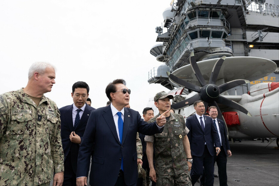 ２５日、韓国南部・釜山に寄港中の米海軍の原子力空母「セオドア・ルーズベルト」に乗艦した尹錫悦大統領（左から３人目）（韓国大統領府提供）