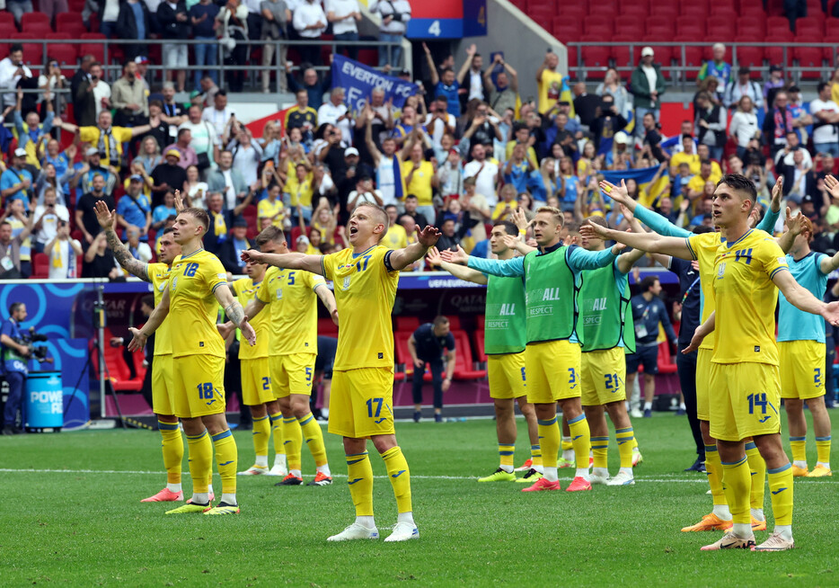 サッカーの欧州選手権は２１日、１次リーグＥ組の第２戦で、ウクライナがスロバキアに２―１で逆転勝ちし、１６強へ望みをつないだ。写真は喜ぶウクライナの選手＝ドイツ・デュッセルドルフ
