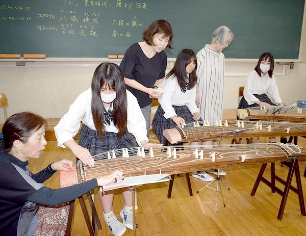 三松会の会員らに教えてもらいながら、琴の演奏に挑戦する生徒たち