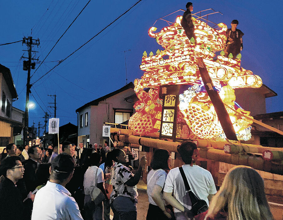 大行燈を間近で見物する特別観覧席の参加者＝小矢部市津沢