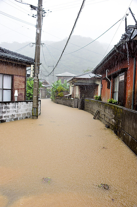 大雨の影響で一部が冠水した道路＝12日午前10時50分ごろ、鹿児島県宇検村湯湾