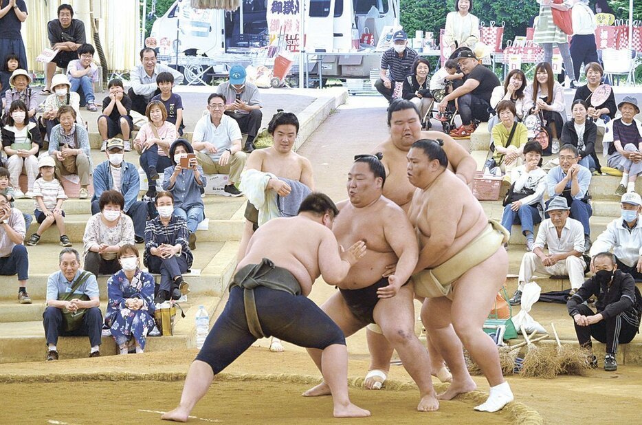 中学生に胸を出す幕下の出羽ノ龍さん（中央）。御嶽海関（右）や、出羽海部屋一の巨体を誇る幕下の出羽ノ城さんも加わり3人で相手をした