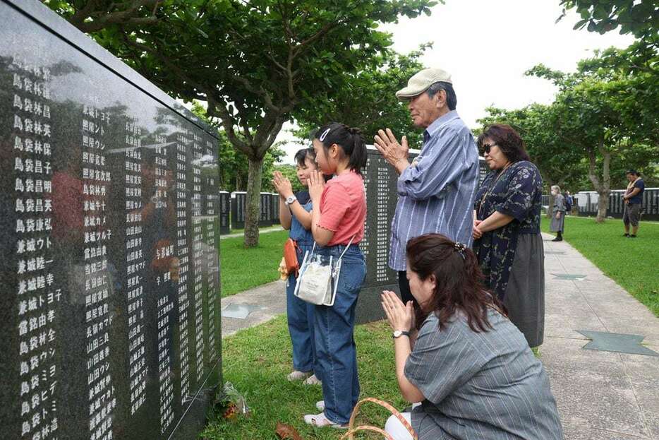 沖縄全戦没者追悼式が開かれる平和祈念公園の「平和の礎」には多くの人が訪れた。親族が手合わせていた＝２３日午前７時５８分、沖縄県糸満市（彦野公太朗撮影）
