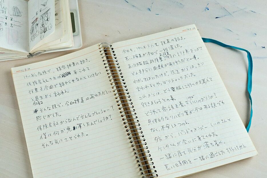 事故後、保険会社の人の勧めで日記をつけ始めた。「どうやって家族を養っていけばいいのだろうか？」など、葛藤が綴られている。左上は、娘が書いた「がんばれ」の文字