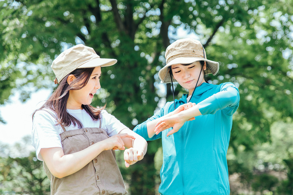 夏のキャンプで虫刺され対策する女性キャンパー