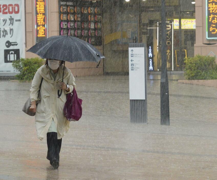 大雨の中、静岡県の熱海駅前を歩く人＝28日午後0時29分