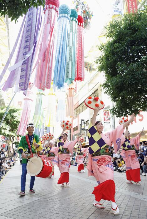 仙台市で開幕した「東北絆まつり」で披露された山形花笠まつり。仙台七夕まつりの飾り付けの下、大勢の見物客でにぎわった＝8日午後