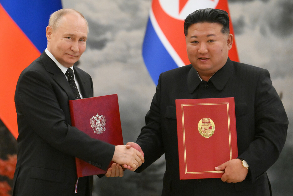 １９日、平壌で新条約に署名後、握手を交わすロシアのプーチン大統領（左）と北朝鮮の金正恩朝鮮労働党総書記