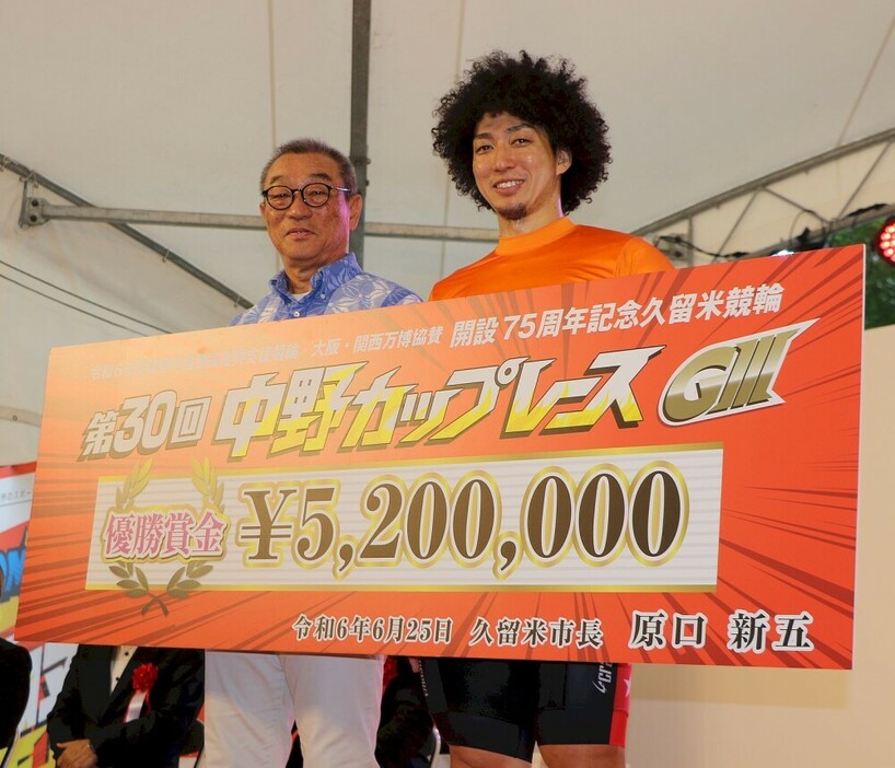表彰式で中野浩一氏（左）に優勝の賞金ボードを手渡される山崎賢人