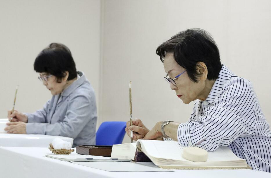 原爆死没者名簿に記帳する池亀和子さん（右）と中本信子さん＝3日午前、広島市役所