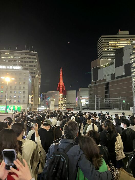 ［写真］大阪駅周辺では、皆既月食を見ようと多くの人が空を見上げていた＝8日夜、大阪市北区で