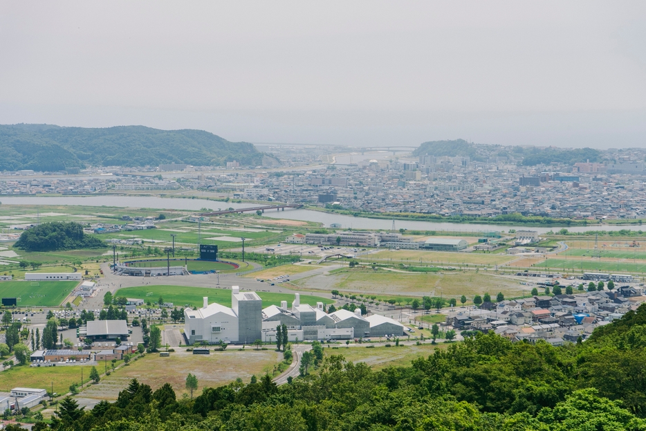 トヤケ森山から見た石巻の風景。中央を流れるのが旧北上川。手前の白い建物は21年4月にオープンした市の複合文化施設