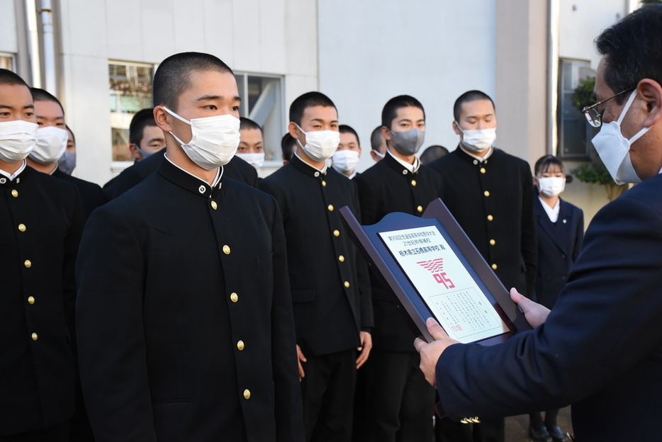 県高野連の菅野光広会長（右）から表彰盾を受け取る石橋の横松誠也主将（２年）＝栃木県下野市石橋の同校で２０２２年１２月２３日、鴨田玲奈撮影