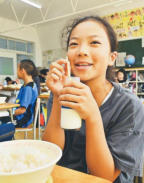 麦ストローで牛乳を飲む児童。15センチほどの長さがあるので、高さがある瓶牛乳でも問題なく飲める（群馬県玉村町で）