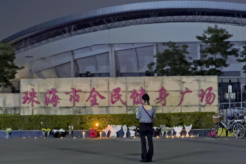 多くの人がはねられた広東省珠海市の体育センターに向かい手を合わせる女性（１２日）＝ＡＰ