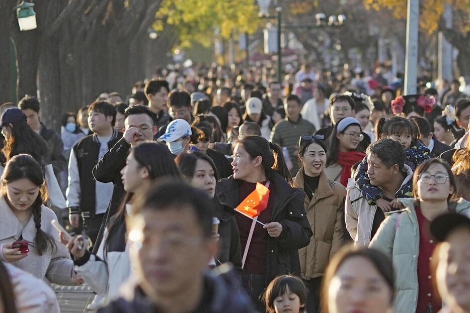 北京市内を歩く人たち＝16日（共同）