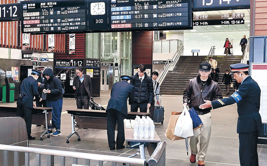 疲れた表情で改札を出る北陸新幹線の利用客＝２７日午前３時、富山駅