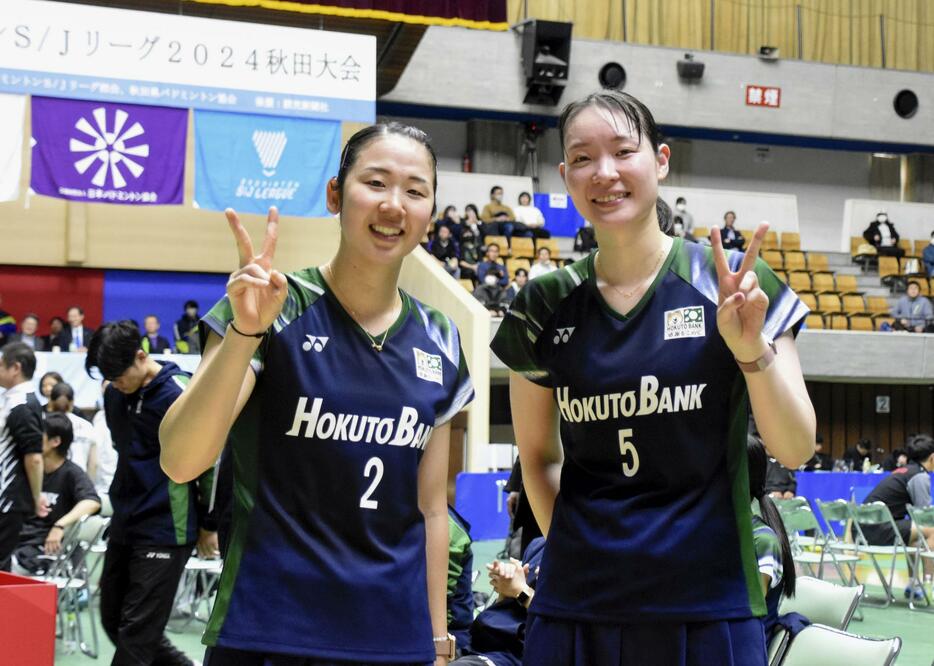 試合後に笑顔を見せるバドミントン女子ダブルスの永原和可那（左）と松本麻佑＝秋田県立体育館