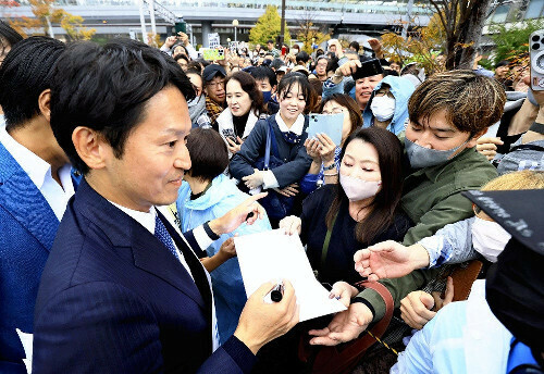 知事選期間中、聴衆にサインをする斎藤氏（１６日、兵庫県西宮市で）