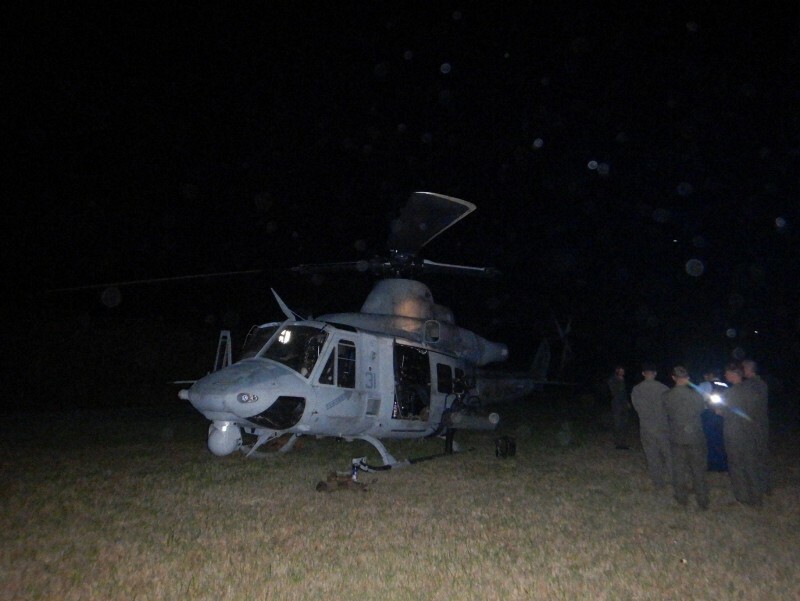 沖縄県国頭村の草地に着陸した米海兵隊の多用途ヘリコプターUH1と米軍関係者ら（右端）＝同村提供