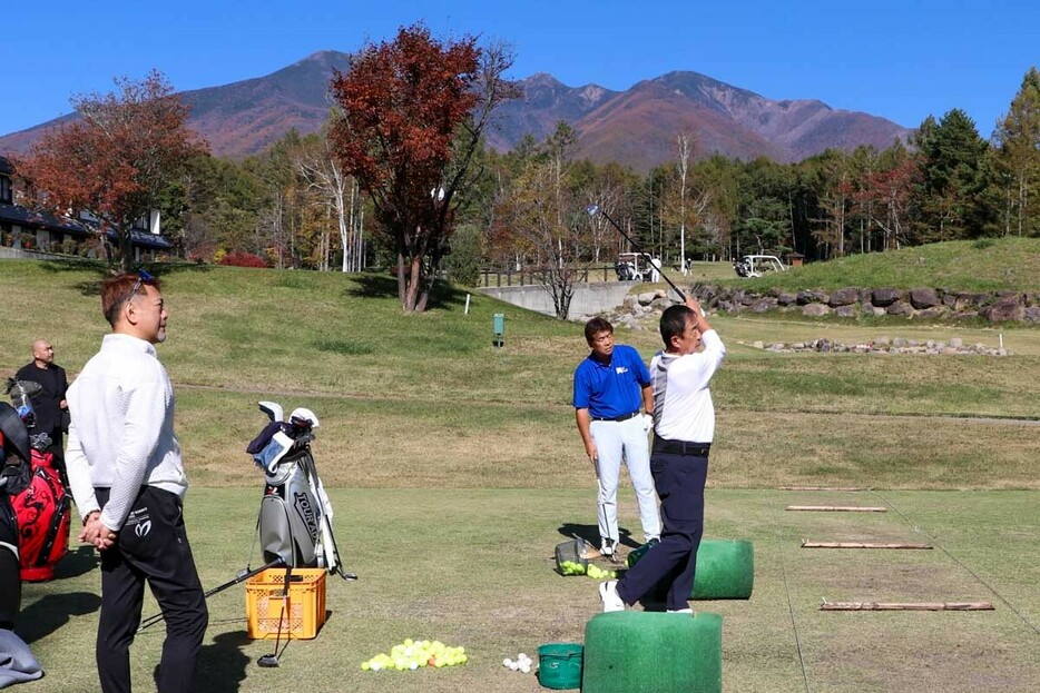 ドライビングレンジで練習する高見和宏（手前）と小溝高夫。左が杉本和隆医師　写真：清流舎