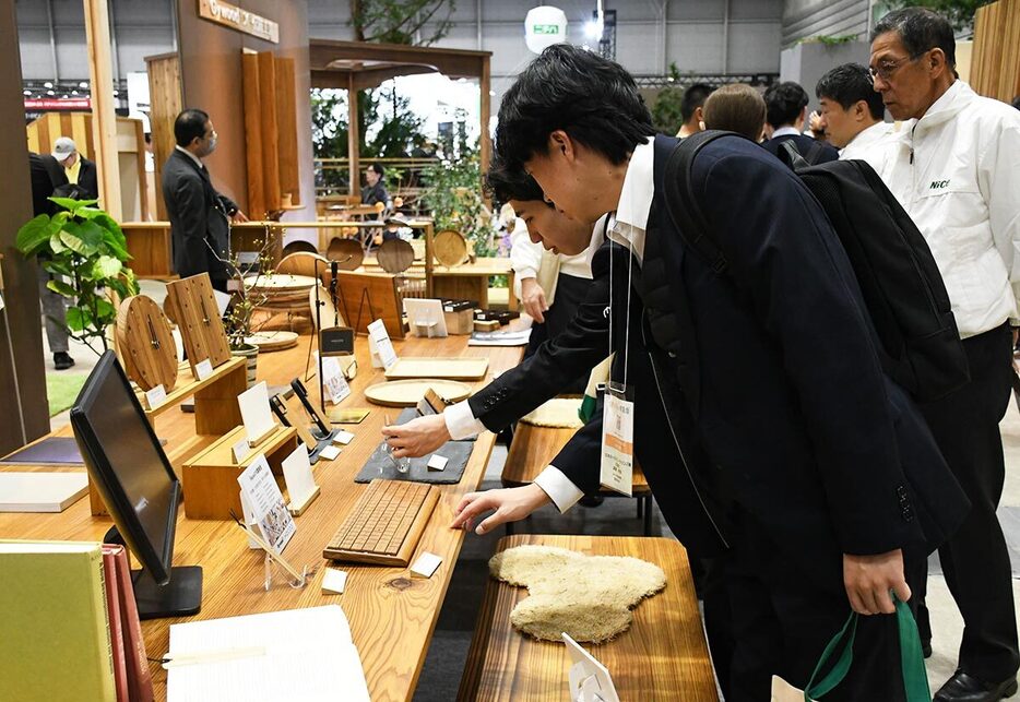 木質化したキーボードなどに見入る来場者ら＝横浜市西区