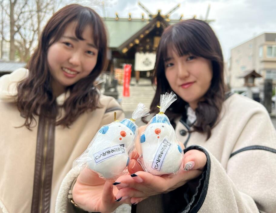 札幌諏訪神社で雪だるまの形のおみくじを持つスノーマンのファン