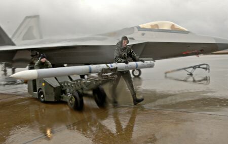 空対空ミサイル「AMRAAM」を「F-22ラプター」からリロードする米空軍兵士（2006年1月30日撮影、米空軍のサイトより）