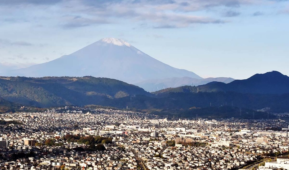 秦野市街地の後方に望む富士山。山頂部に冠雪が確認できた＝１９日、同市内