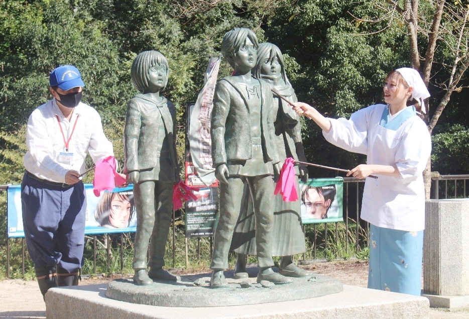 銅像をはたいてほこりを取り除く参加者＝日田市大山町の大山ダム