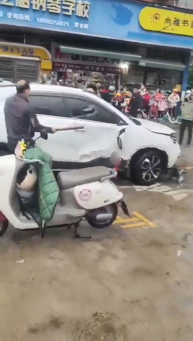 　中国中部の湖南省にある小学校前で１１月１９日朝、複数の生徒が車にはねられて負傷した。負傷者の数は現在確認中だという。写真は事故後、小学校の外の道路に止まっていた白い車。ソーシャルメディアの動画から取得（２０２４年　ロイター）