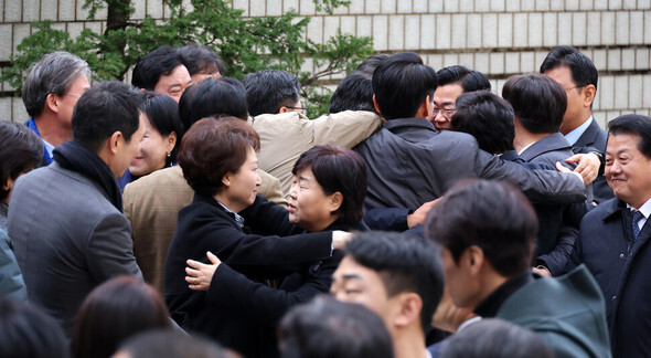 25日午後、ソウル瑞草区のソウル中央地裁で開かれた偽証教唆の一審で無罪判決を受けたイ・ジェミョン代表が裁判所を出た後、地裁を訪れた共に民主党の議員らが抱擁しあっている＝写真共同取材団