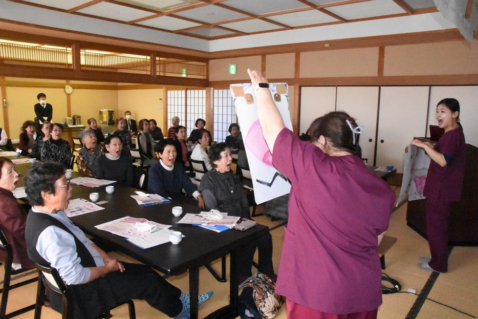 口と舌の体操に挑戦する来場者=岡山県津山市で