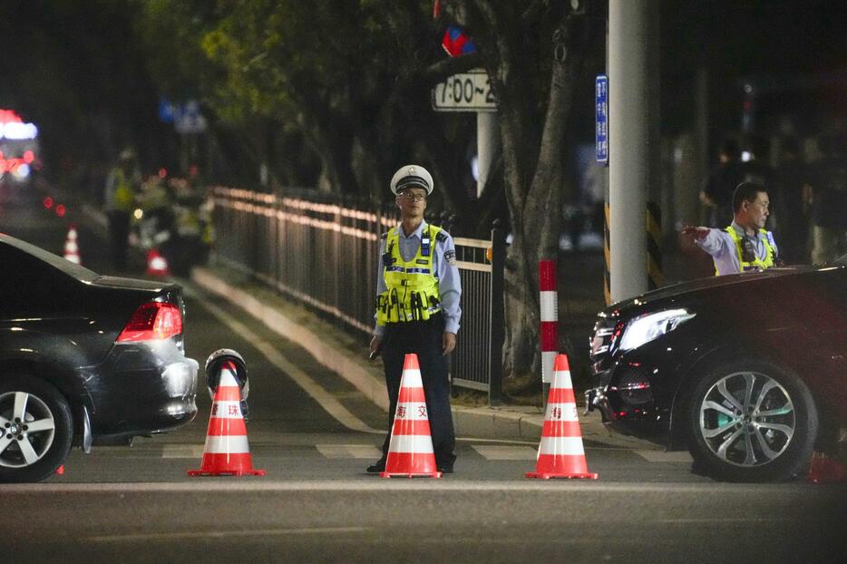 現場となった体育施設の周辺を規制する治安当局者＝11日、中国広東省珠海市（共同）