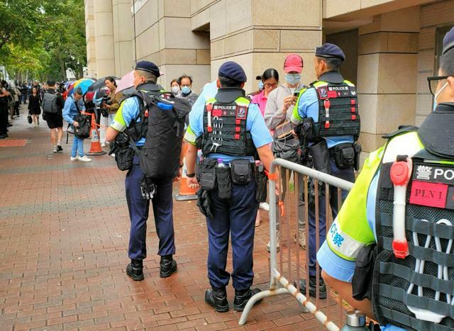 香港の裁判所前に列をつくる傍聴希望者。周辺では警察官が警戒していた=2024年11月19日、香港、朱延雄撮影