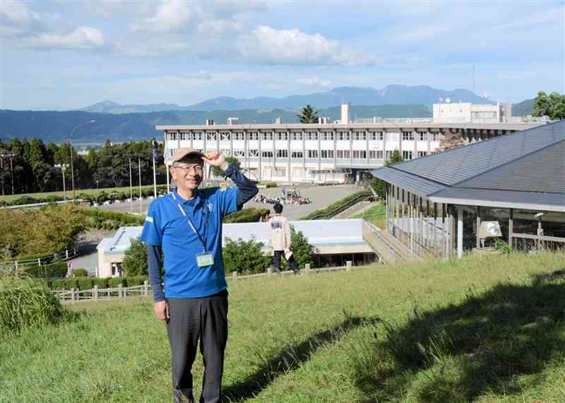 開所60周年を迎えた国立阿蘇青少年交流の家と牛田卓也所長。高岳の裾野にあり、阿蘇谷や北外輪山を見渡せる＝10月9日、阿蘇市