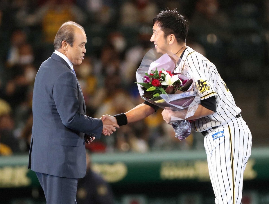 20年、藤川（右）の引退セレモニーで花束を贈った岡田氏。今後はオーナー付顧問として藤川監督をサポートする