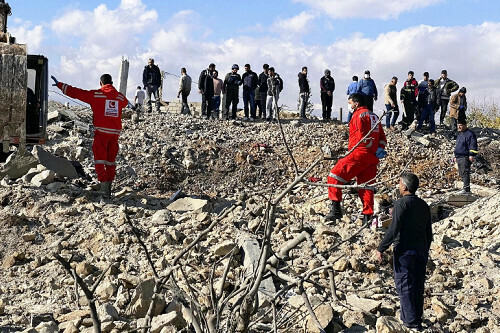 ２１日、レバノン東部でイスラエル軍の攻撃により崩壊した建物周辺に集まる救助関係者ら＝ＡＦＰ時事