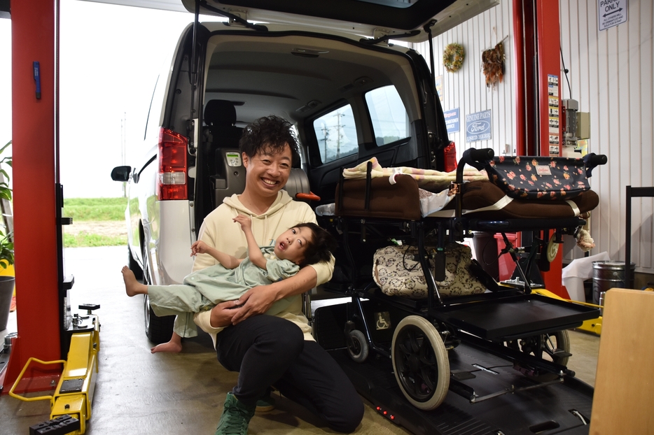 自動のリフトを備えたデモカーと、蒼空ちゃんを抱っこする古畑さん