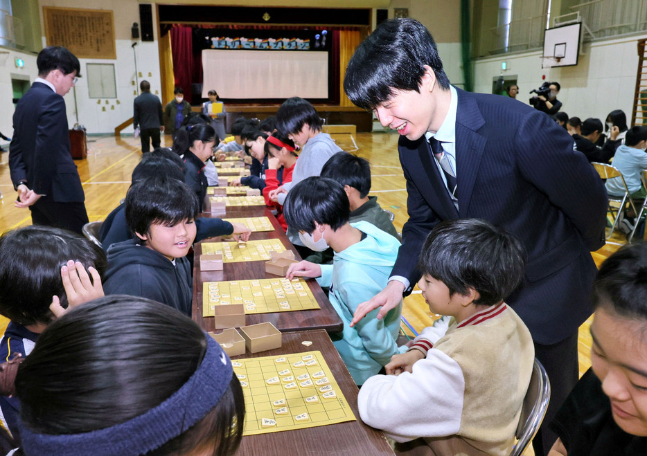 愛知県瀬戸市の母校效範小で行われた授業にサプライズで登場し、6年生の対局を見守る将棋の藤井聡太七冠＝21日午後（代表撮影）