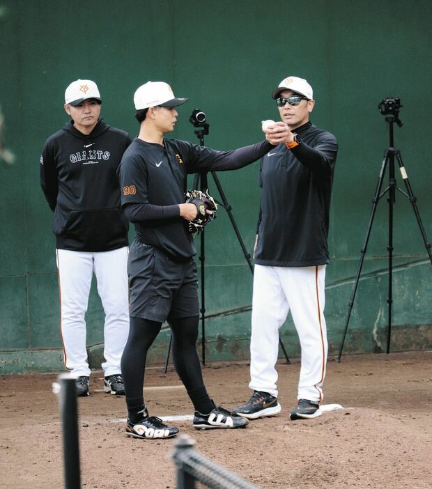 阿部監督（右）からブルペンで直接指導を受ける山田（中）