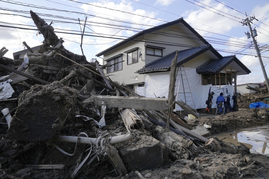 豪雨被害を受けた石川県輪島市町野町の住宅で、作業に当たる災害ボランティア＝10月20日