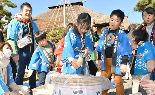 高僧・沢庵が考案したとされるたくあん漬けをつけ込む子どもたち＝上山市・春雨庵