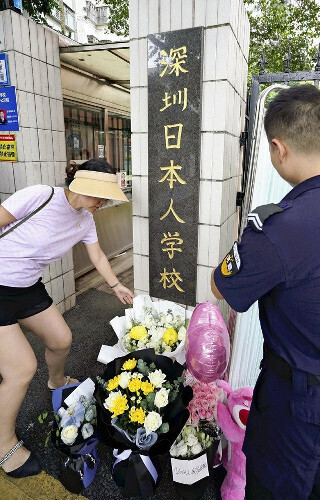 日本人学校の校門に献花する中国人女性（９月２０日）